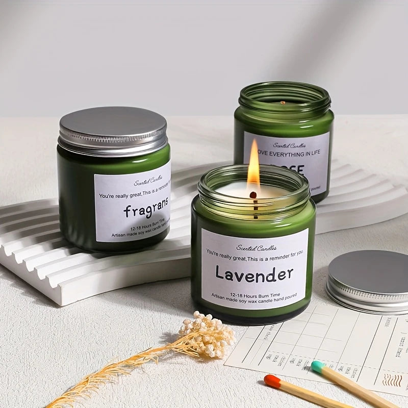Green candles with labels on a light surface with matches and dried flowers.