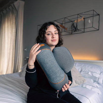 Woman holding a blue pillow in a bedroom setting