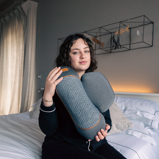 Woman holding a blue pillow in a bedroom setting